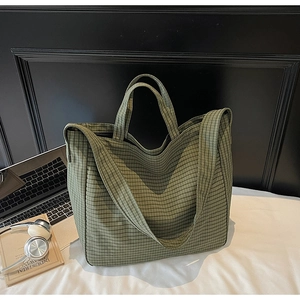 Detail of green checkered canvas tote bag with sturdy handles and wide shoulder strap