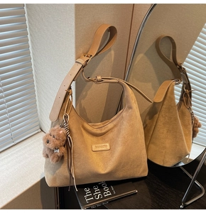 Close-up of khaki suede tote bag with BANATU brand label and plush dog charm accessory