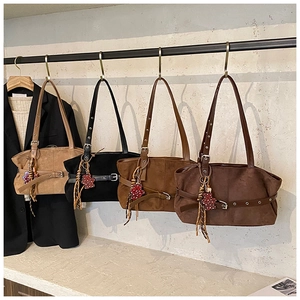 Close-up of four suede tote bags in various earth tones with leopard bear charms