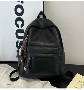 Close-up of black leather backpack with Hoog embossing and cute rabbit charms