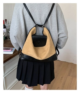 Detail of vintage dual-tone backpack with khaki suede and black faux leather on model