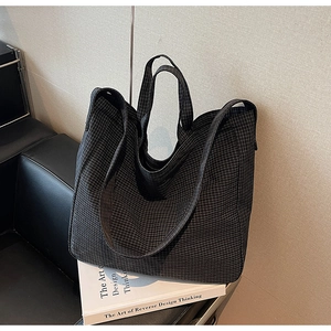 Macro shot of durable black checkered canvas texture and large tote bag craftsmanship