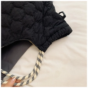 Detail of black quilted puffer tote with checkerboard woven rope strap and drawstring