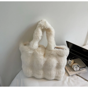 Vue détaillée du cabas en fausse fourrure blanche matelassée avec ordinateur et casque