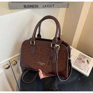 Detail of dark brown Boston bag featuring leopard print suede and gold-tone hardware