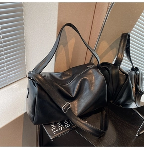 Close-up of the soft black leather tote bag featuring adjustable strap and silver zipper detail