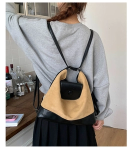Detail of contrast ginger canvas and black leather backpack on female model