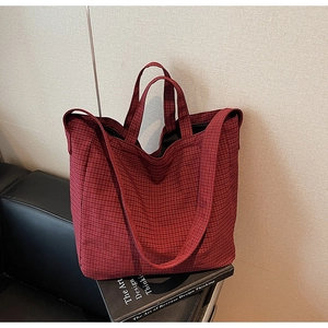 Detail of red checkered canvas tote bag with woven texture on vintage books