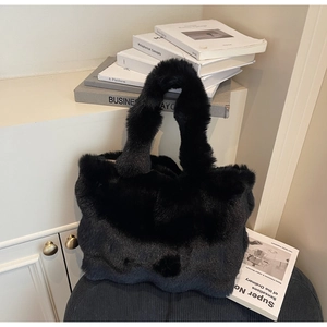 Détail d'un sac cabas en peluche noire avec texture en fausse fourrure douce dans un décor