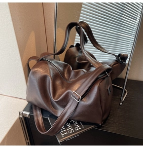 Macro shot of dark brown polished PU leather texture and silver hardware on a tote bag
