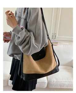 Detailed side view of a large brown suede tote bag with black leather patchwork strap