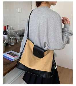 Close-up of khaki canvas and black leather crossbody bag with adjustable metal buckle