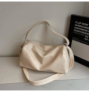 Macro detail of creamy off-white leather tote showing matte texture and fine wrinkles