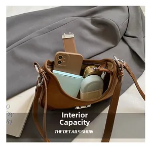 Detail view of the spacious inner compartment of the brown retro shoulder bag with essentials