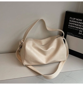 Close-up of a cream white vintage Boston pillow bag with soft leather texture and handle