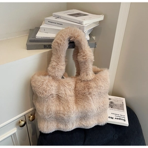 Détail d'un sac cabas en peluche beige doux avec texture en fausse fourrure sur coussin