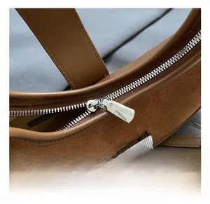 Macro detail of high-quality silver zipper and premium suede stitching on shoulder bag