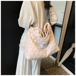 Pink quilted tote bag with embroidery, drawstring closure, and blue shoulder strap detail