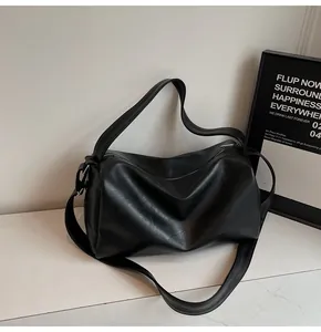 Close-up of minimalist black oversized tote with premium leather texture and silver zipper