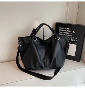 Détail du sac cabas noir en similicuir texturé avec une large bandoulière en tissu