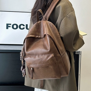 Rear view of a vintage brown faux leather backpack with refined texture and a zip pocket