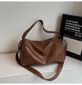 Detailed macro view of soft brown PU leather texture and metal ring on vintage tote bag