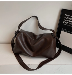 Detail of soft dark brown PU leather texture and zip closure on the tote bag