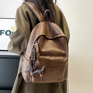 Detail view of vintage brown PU backpack with chocolate and dachshund shaped charms