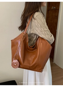 Minimalist caramel brown leather tote bag with retro glossy finish and shoulder strap