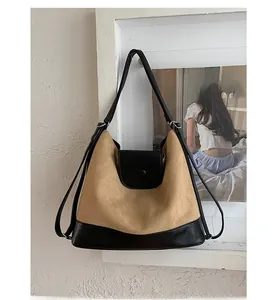 Detail of vintage matte tote bag showing brown suede and black leather patchwork
