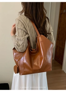 Detailed back view of a large brown vintage tote bag with matching round coin purse charm