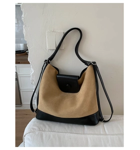 Detail of khaki suede and black leather patchwork bag with sleek metal strap buckle