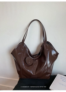 Close-up of a retro dark brown glossy bucket bag in a minimalist lifestyle setting