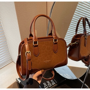 Detail of vintage caramel matte leather boston bag with stylish texture and round handle