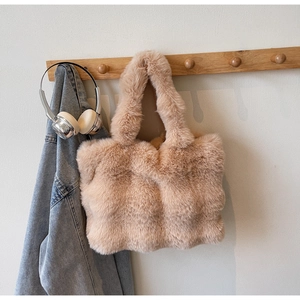 Détail de la texture d'un sac cabas en fausse fourrure kaki sur un crochet en bois