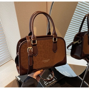 Close-up of vintage brown matte leather shoulder bag with gold clasp and mirror reflection