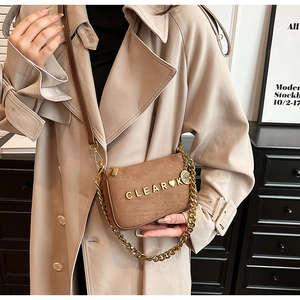 Detailed view of brown matte suede small square bag with gold metal chain and logo