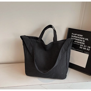 Detail of black and white grid canvas tote bag with shoulder strap and marble display