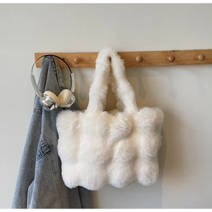 Détail d'un sac cabas en peluche blanche avec texture matelassée en fausse fourrure douce