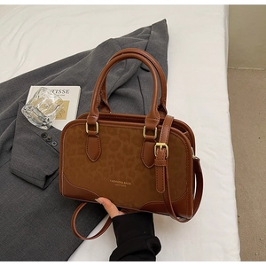Close-up of a retro brown crossbody bag featuring leopard print texture and gold hardware