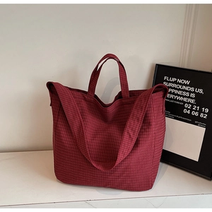 Detail of red and white checkered canvas tote bag showing dual handles and wide strap