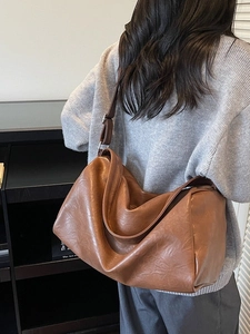 Vintage caramel brown leather hobo bag with wide shoulder strap and silver metal buckle
