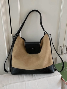 Large capacity khaki and black suede tote bag with shoulder strap in a home setting