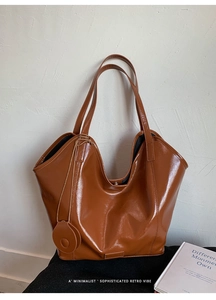 Detail shot of the glossy brown tote bag with retro minimalist vibe and sleek handle