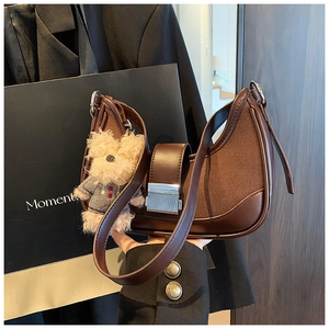 Detail of vintage brown half-moon bag with suede stitching and silver metal buckle
