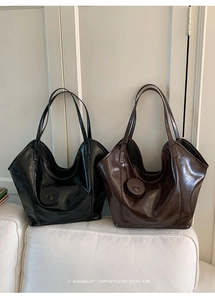 Detail of minimalist retro tote bags in black and dark brown oil wax leather texture