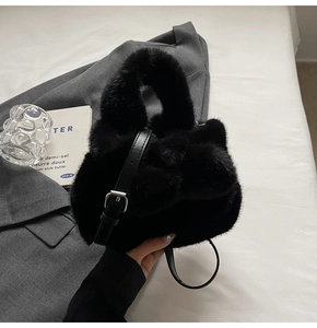 Détail du sac seau en fausse fourrure noire avec bandoulière réglable et texture peluche