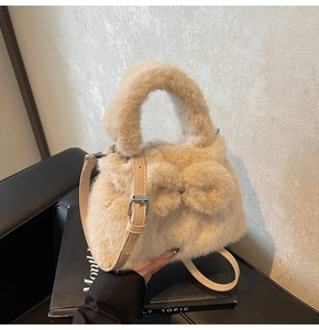 Close-up of plush bucket bag featuring soft cream faux fur and a matching bow decoration