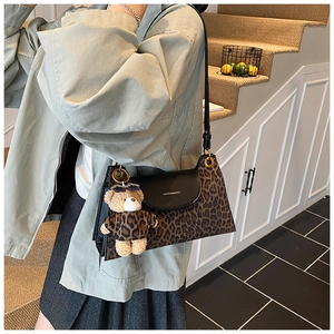 Détail du sac léopard en fausse fourrure avec rabat en cuir et breloque ours mignon