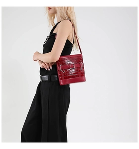 Détail du sac à bandoulière rouge motif crocodile avec anneaux et boucles en métal